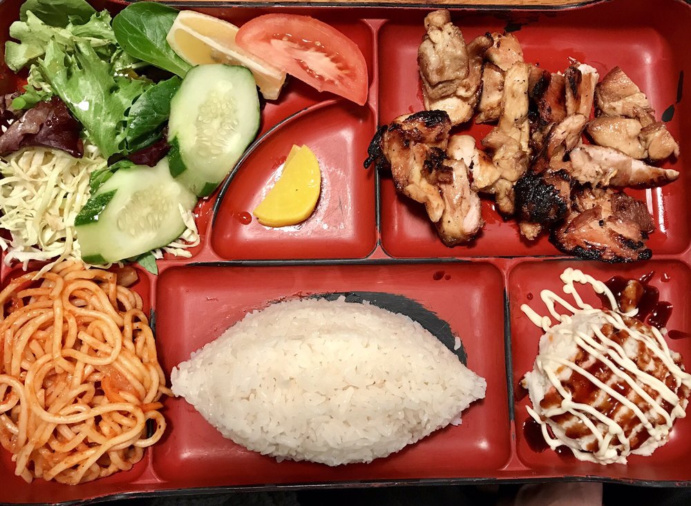 Bento box with grilled chicken, rice, salad and noodles