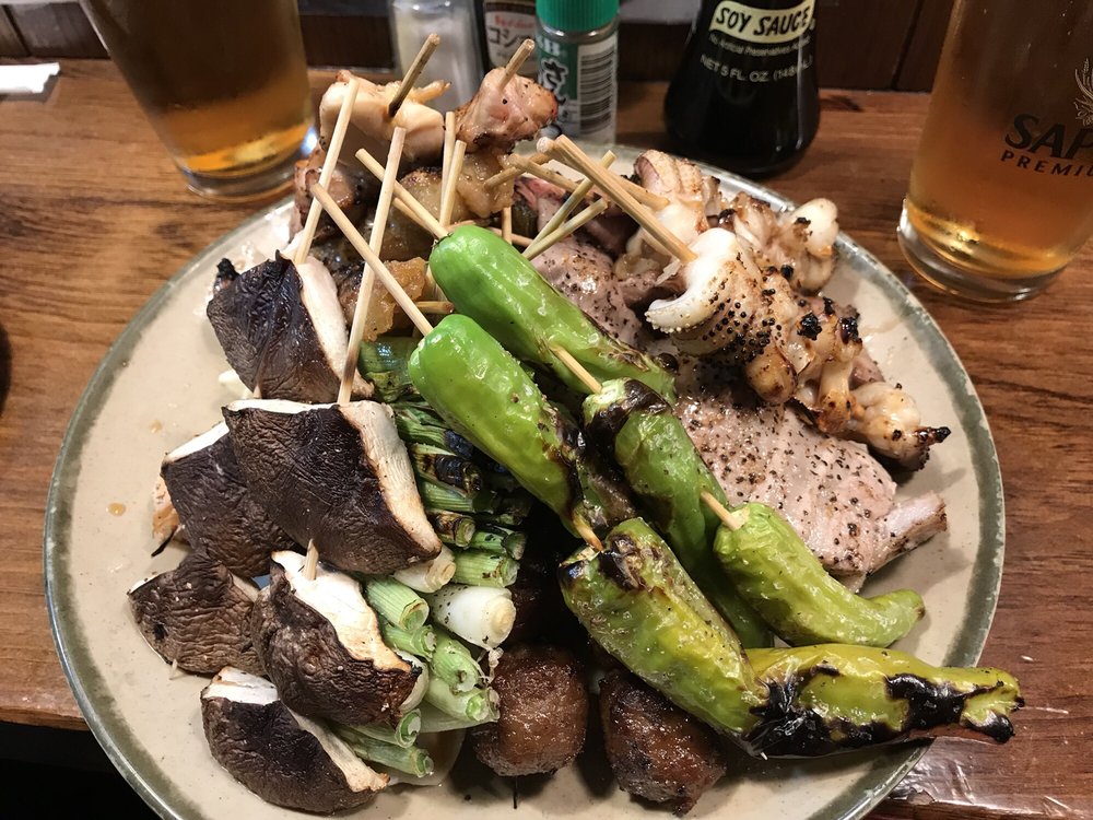 Plate of grilled skewers, shishito peppers and mushrooms